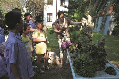 镇江城管局带环卫工人子女看盆景展